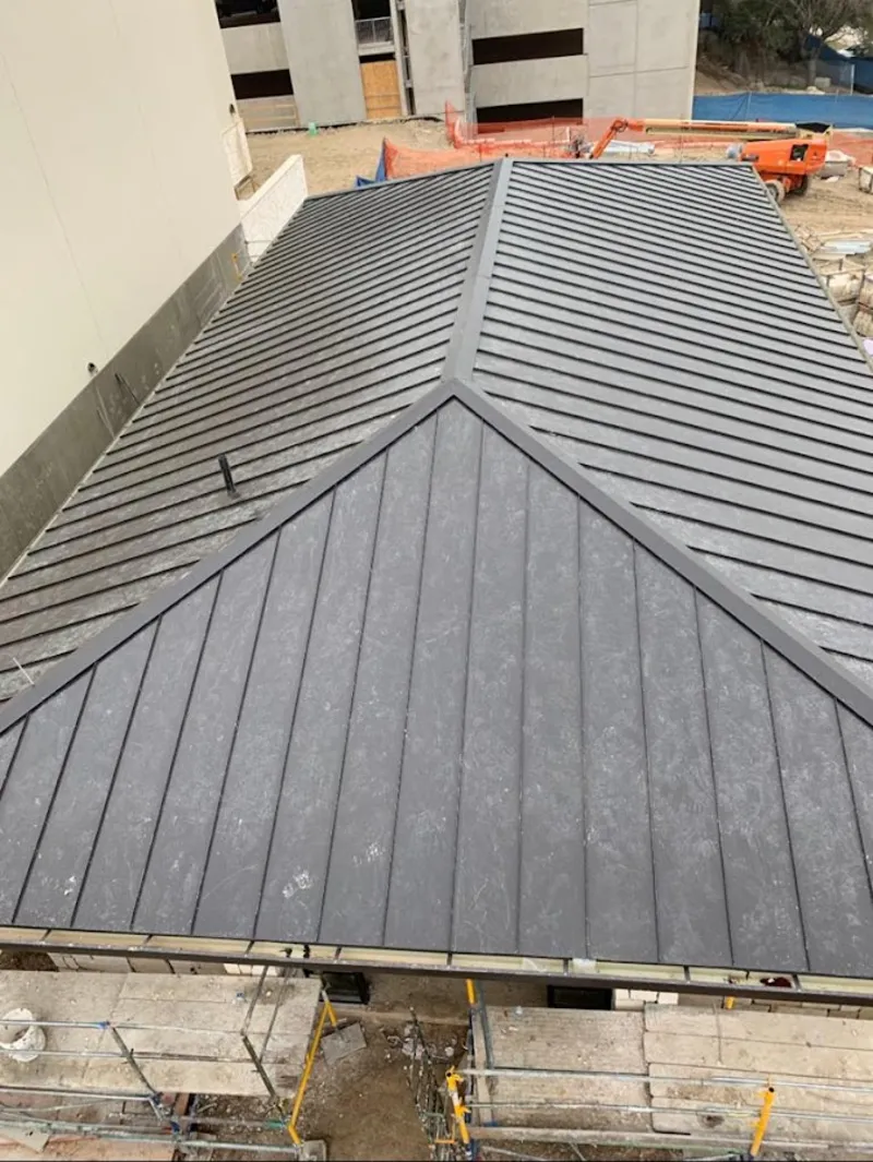 Commercial metal roof construction with crane equipment in Stafford